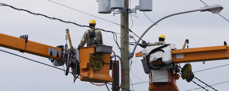 Deux électriciens travaillant sur des lignes à haute tension.