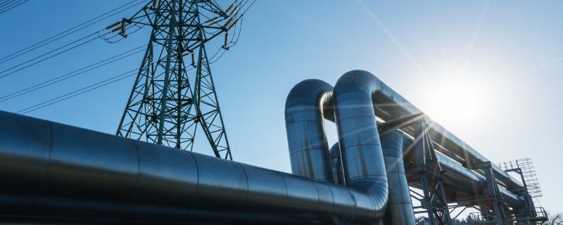 Deux pipelines de gaz devant une tour à haute tension.