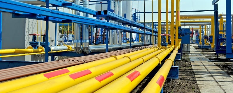 Plusieurs tuyaux jaunes de gaz naturel qui mènent vers une station de traitement de gaz naturel.