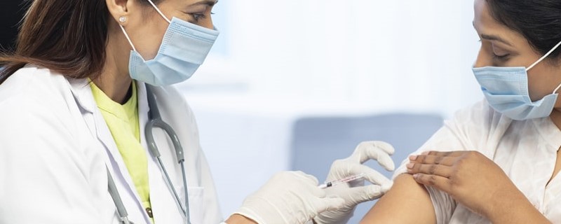 médecin injecte le vaccin à une patiente