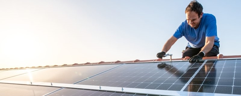 Ouvrier professionnel installant des panneaux solaires sur le toit d’une maison
