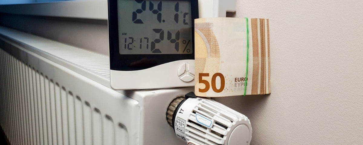 Un thermomètre et un paquet de billets de 50 euros sont placés sur le radiateur de chauffage avec un thermostat. 