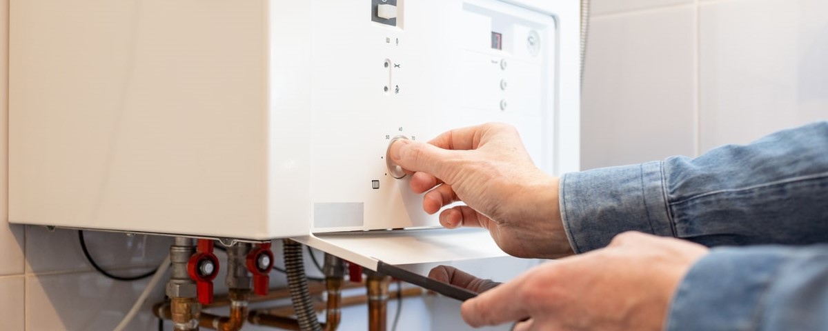 L'homme blanc abaisse la température de la chaudière à gaz de sa maison en raison de la crise énergétique