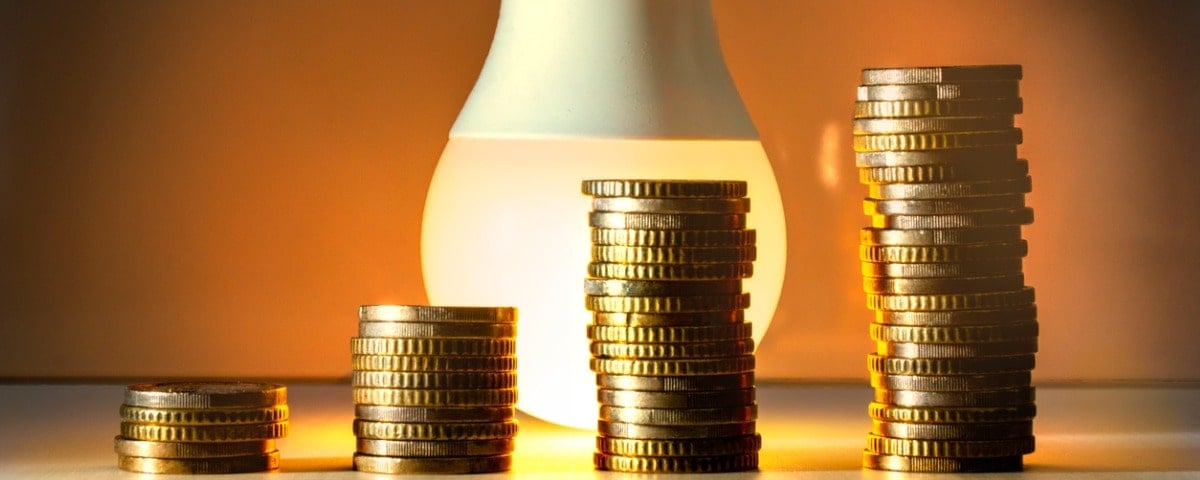 Lampe à économie d'énergie avec pièces de monnaie Coût, efficacité et concept d'économie d'énergie.