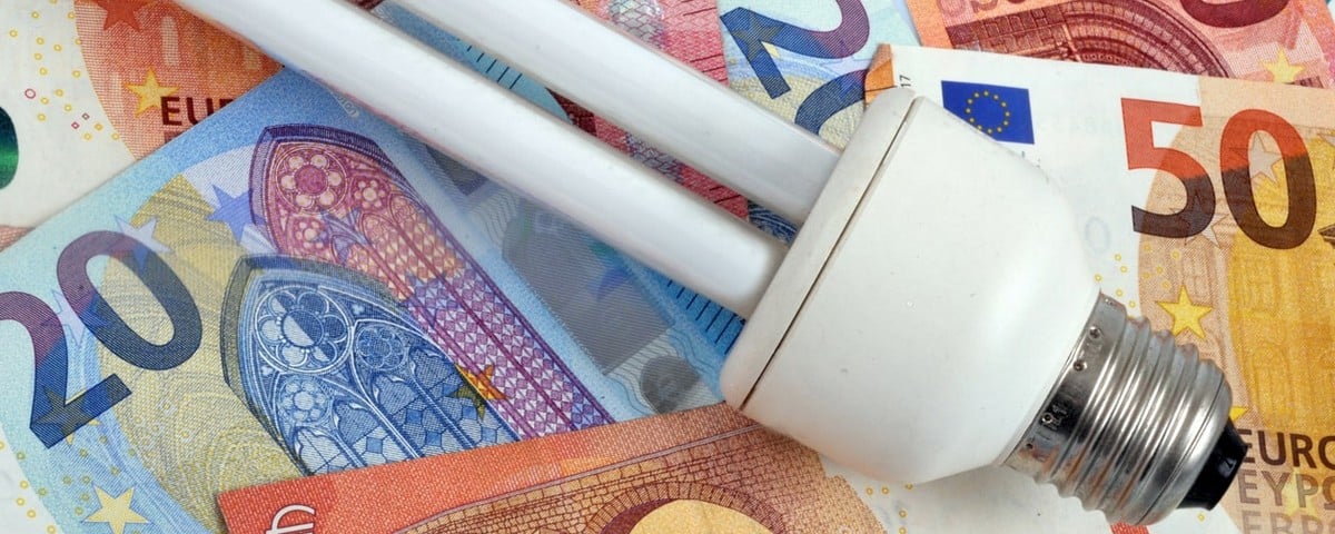 Concept de dépense d'électricité avec une ampoule à basse consommation sur les billets de banque en euros