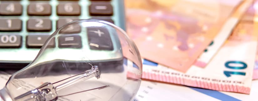 Facture d’électricité à côté d’une calculatrice, d’une ampoule et d’argent. Concept de prix de l’électricité